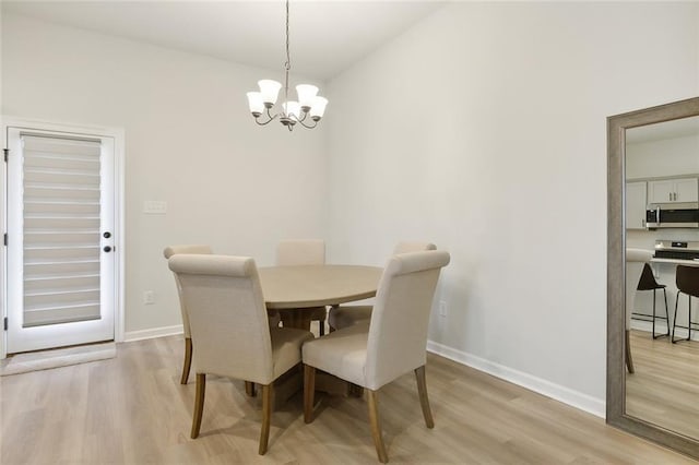 dining space featuring an inviting chandelier and light hardwood / wood-style flooring