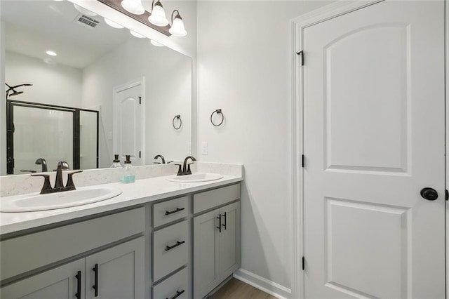 bathroom with hardwood / wood-style floors, vanity, and walk in shower