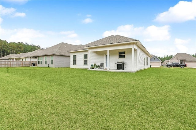 rear view of property featuring a yard and a patio area