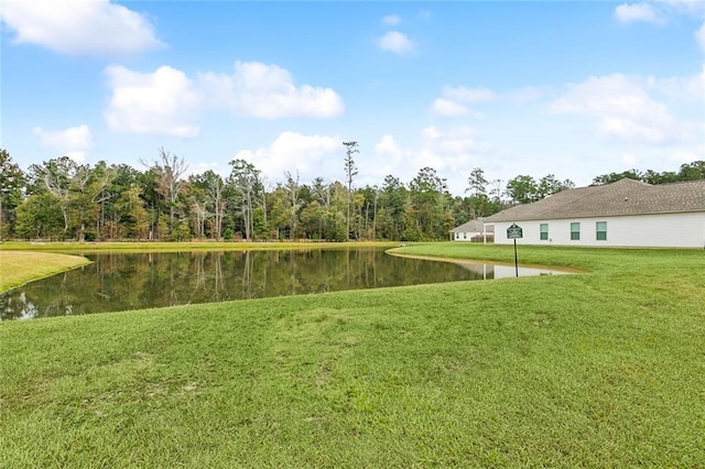 view of community featuring a lawn and a water view