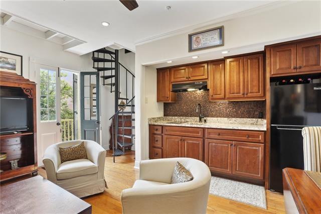 kitchen featuring sink, black fridge, light hardwood / wood-style flooring, backsplash, and crown molding