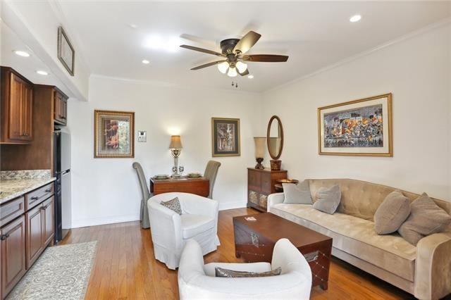 living room with light hardwood / wood-style flooring, ceiling fan, and ornamental molding