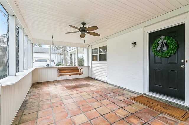 unfurnished sunroom with ceiling fan