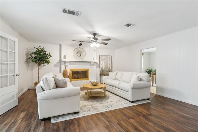 living room with ceiling fan, dark hardwood / wood-style floors, and a brick fireplace