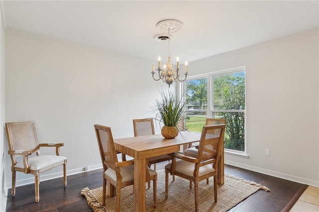 dining room with ornamental molding, hardwood / wood-style floors, and an inviting chandelier