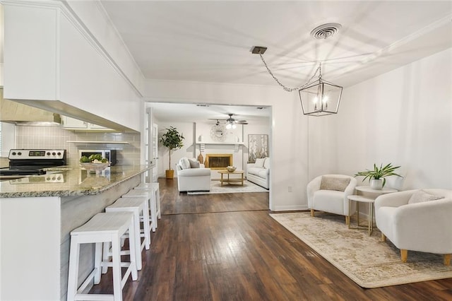 living room featuring dark wood-type flooring and ceiling fan