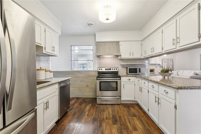 kitchen featuring white cabinetry, custom exhaust hood, kitchen peninsula, stainless steel appliances, and light stone countertops