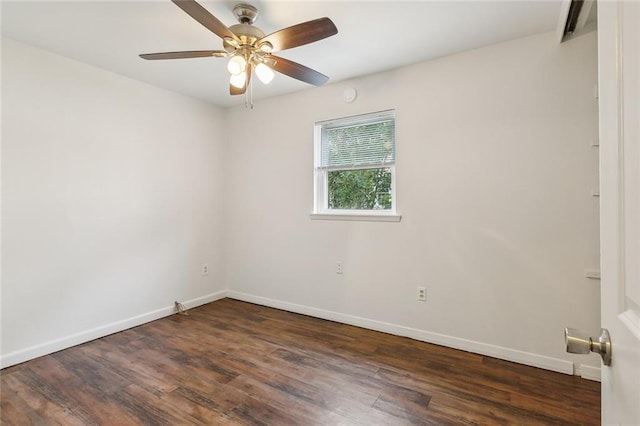 spare room featuring dark wood-type flooring and ceiling fan