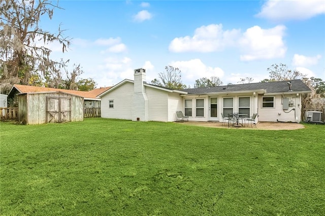 rear view of house featuring a storage shed, central AC unit, a patio area, and a yard