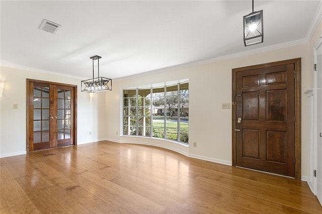 entrance foyer with french doors, crown molding, and wood-type flooring