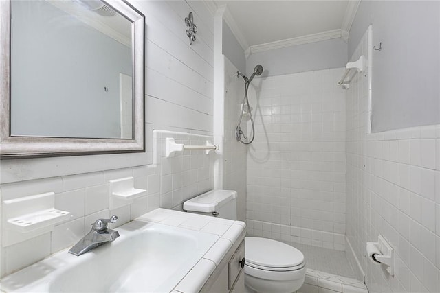 bathroom featuring a tile shower, toilet, tile walls, and ornamental molding