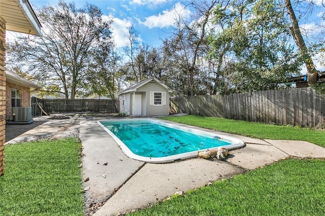 view of swimming pool featuring a yard, a patio, cooling unit, and a storage shed