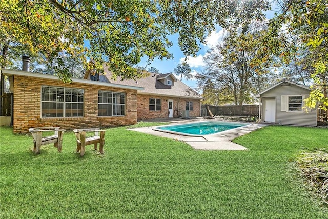 view of swimming pool with a patio area, a yard, and an outdoor structure