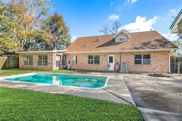 back of property featuring a fenced in pool, a patio area, a yard, and cooling unit