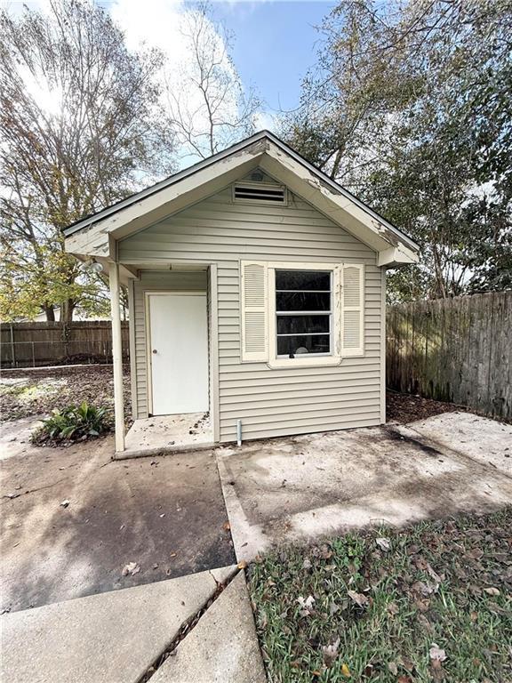 back of house with an outbuilding and a patio