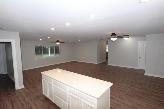 interior space with ceiling fan, a center island, dark hardwood / wood-style flooring, and white cabinetry