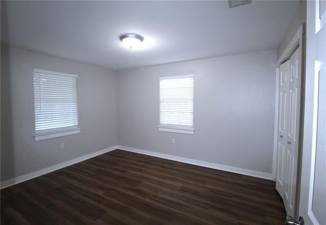 unfurnished bedroom with a closet and dark hardwood / wood-style floors