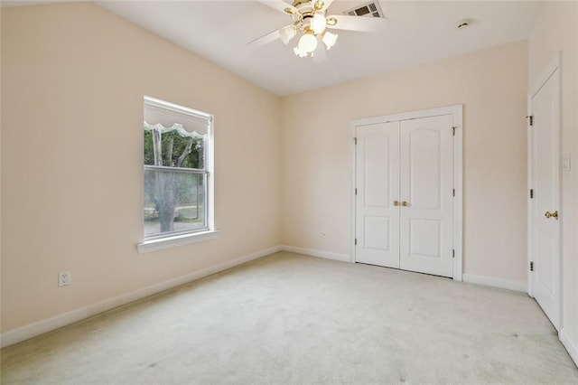 unfurnished bedroom featuring ceiling fan, a closet, and light carpet