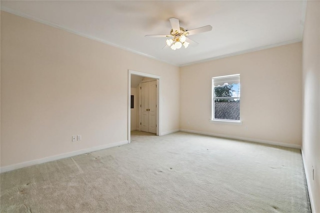 carpeted empty room featuring ceiling fan and crown molding