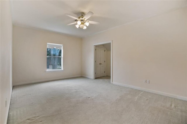 empty room with light colored carpet, ceiling fan, and ornamental molding