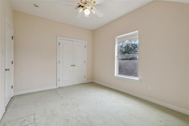 unfurnished bedroom with ceiling fan, a closet, and light carpet