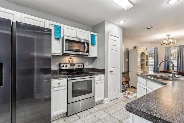 kitchen featuring sink, stainless steel appliances, light tile patterned floors, a notable chandelier, and white cabinets