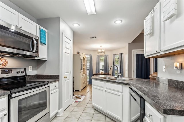 kitchen featuring white cabinetry, sink, light tile patterned flooring, and stainless steel appliances