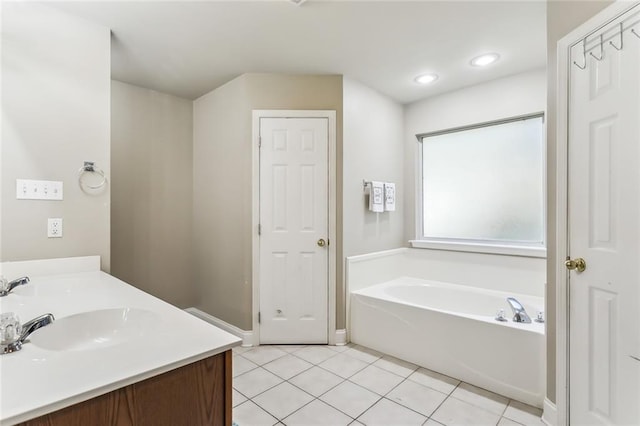 bathroom featuring tile patterned floors, a tub, and vanity