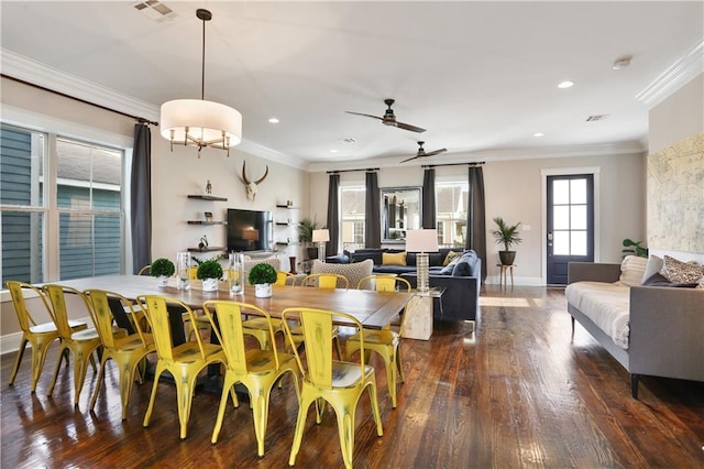 dining room featuring crown molding, dark wood-type flooring, a wealth of natural light, and ceiling fan