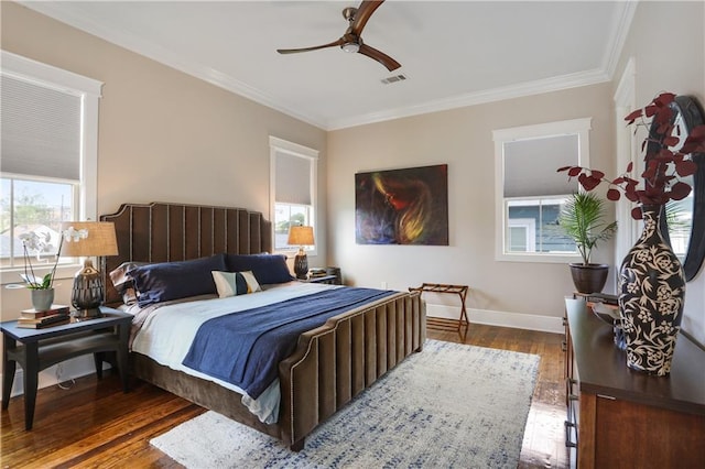 bedroom featuring dark wood-type flooring, ceiling fan, crown molding, and multiple windows