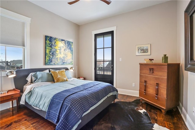 bedroom featuring multiple windows, dark wood-type flooring, access to exterior, and ceiling fan