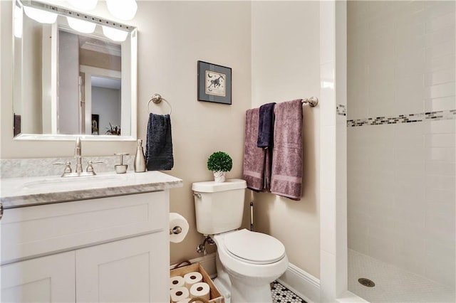 bathroom with tiled shower, vanity, and toilet