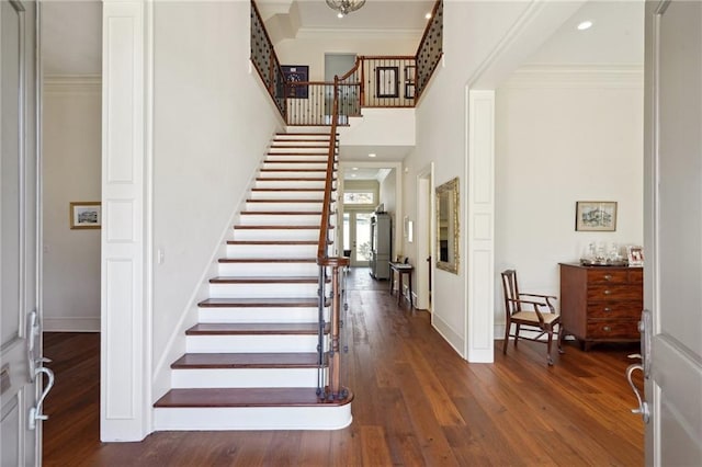 foyer entrance with dark hardwood / wood-style flooring and crown molding