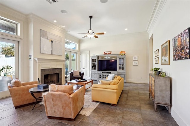 living room featuring ceiling fan, crown molding, and a tile fireplace