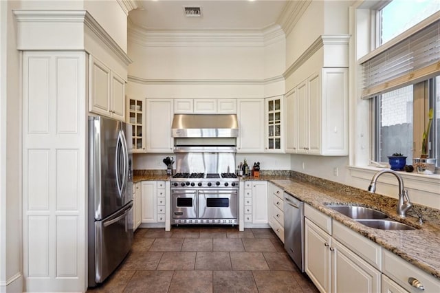 kitchen with light stone counters, sink, white cabinets, and appliances with stainless steel finishes