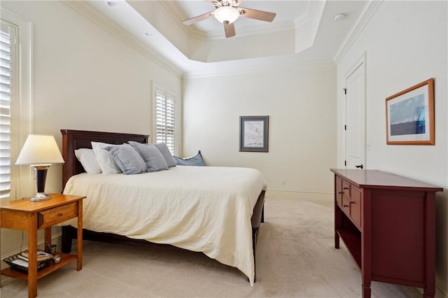 carpeted bedroom featuring ceiling fan, a raised ceiling, and ornamental molding