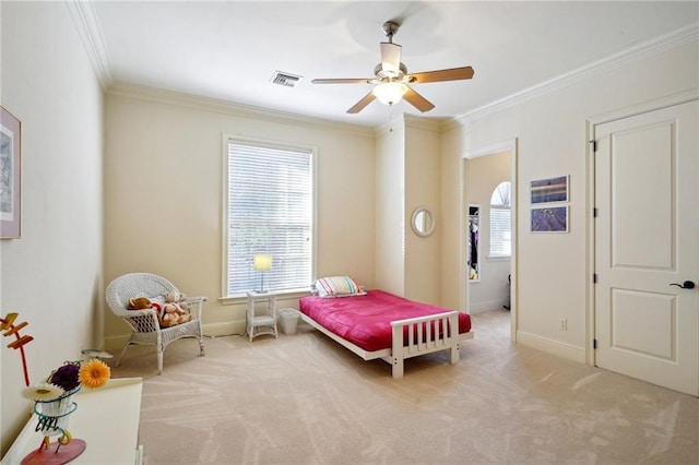 carpeted bedroom featuring ceiling fan and crown molding