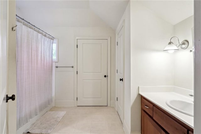 bathroom featuring tile patterned flooring, shower / bath combo, vanity, and vaulted ceiling