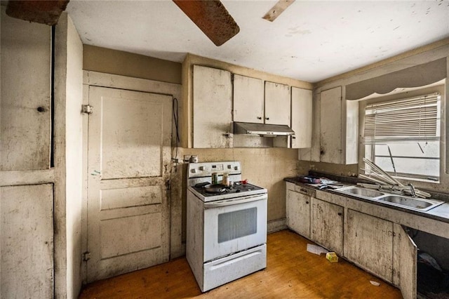 kitchen with sink, white range, and light wood-type flooring