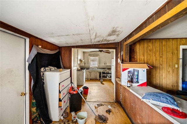 misc room featuring ceiling fan and wooden walls