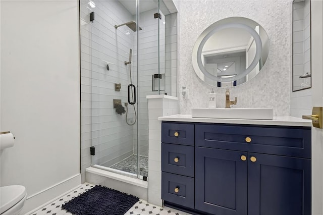 bathroom featuring a shower with door, toilet, vanity, and tile patterned flooring