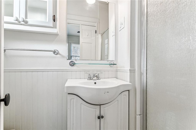 bathroom featuring vanity and wooden walls