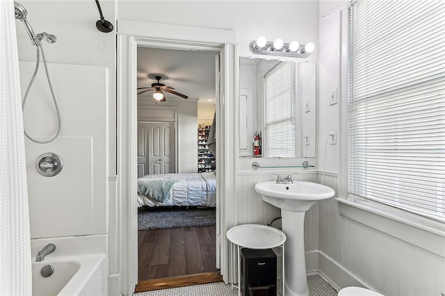 bathroom with hardwood / wood-style flooring, ceiling fan, sink, and shower / tub combo