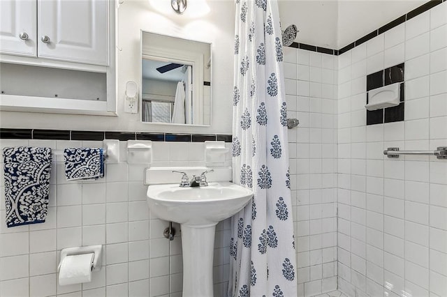 bathroom featuring tile walls and sink