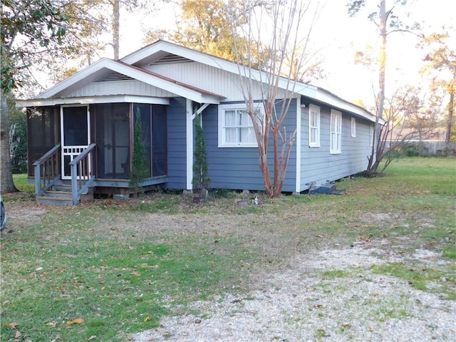 view of front of house featuring a sunroom and a front lawn