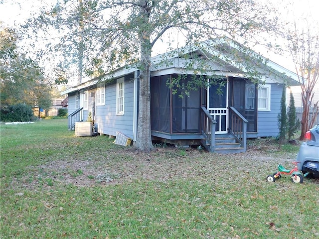 bungalow featuring a front yard and a sunroom