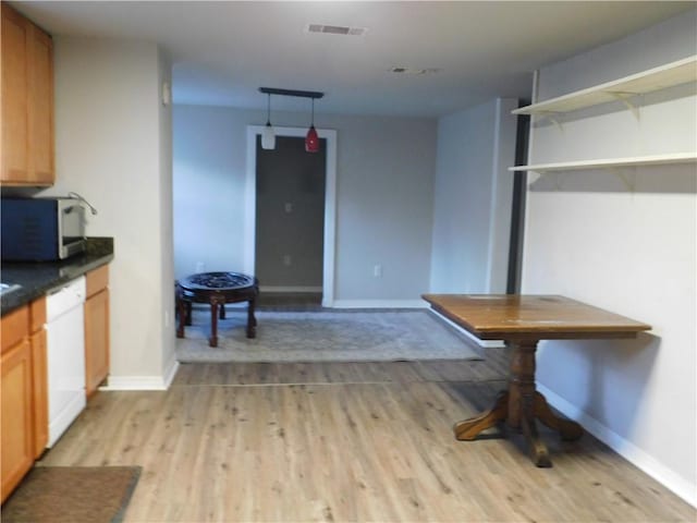 kitchen with dishwasher and light hardwood / wood-style flooring