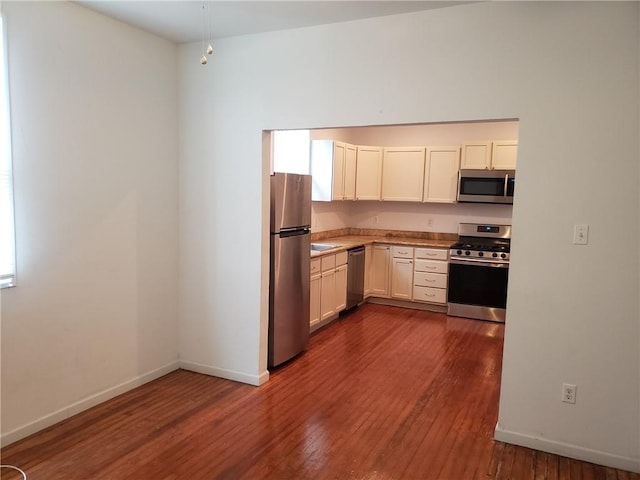 kitchen featuring white cabinets, appliances with stainless steel finishes, dark hardwood / wood-style flooring, and sink