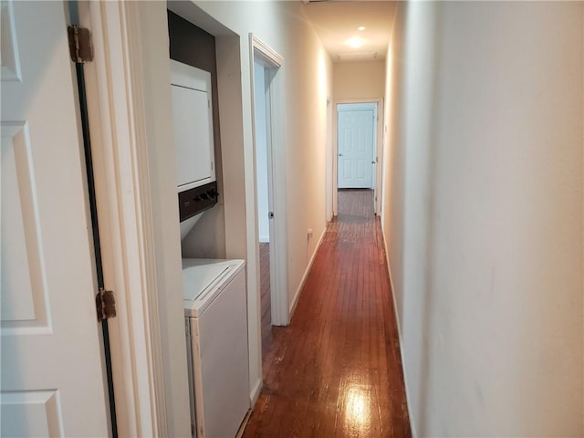 hall featuring stacked washing maching and dryer and dark hardwood / wood-style floors