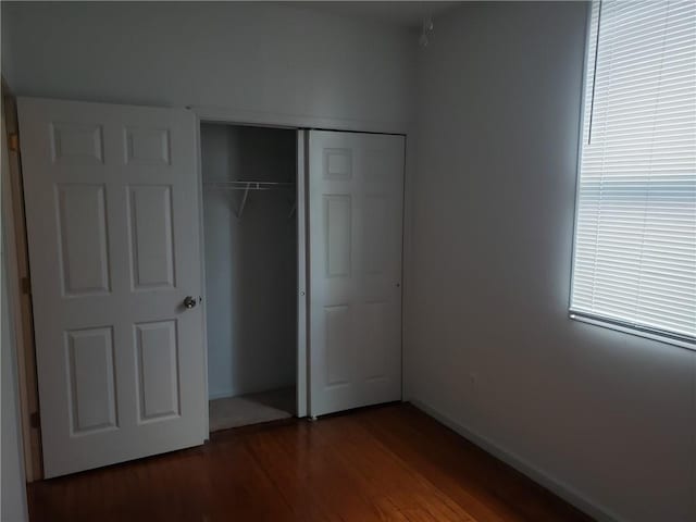 unfurnished bedroom with hardwood / wood-style flooring and a closet